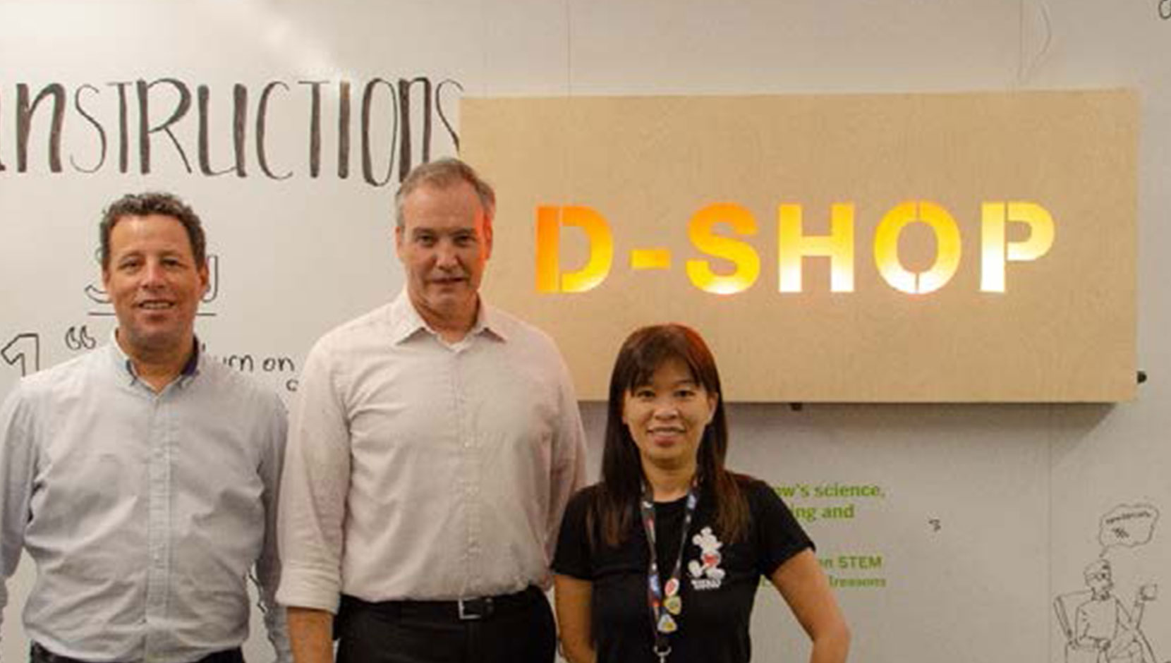 3 SAP staff members from facilities and the D-Shop, standing in front of the sign for D-Shop.
