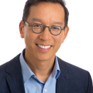 David Wong of ICBC's headshot. He is a man of colour with dark hair and glasses. He is wearing a black suit with a blue collared shirt.