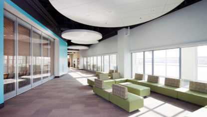 Inside of the Port Authority's head office. A meeting room with a glass wall is on the left, and bright green couches are on the right.