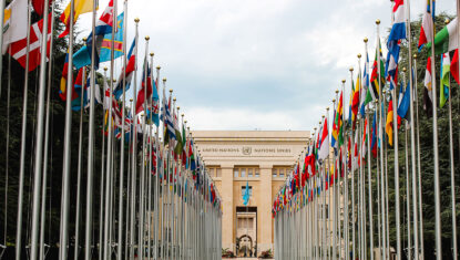 Corridor of international flags on poles outside the United Nations head office.
