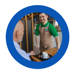 A person with an intellectual disability smiles while serving a customer in a hospitality setting.